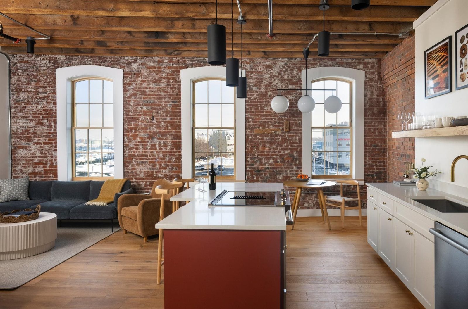 Open kitchen and living area with exposed brick and timber beams at the Evalina Hotel