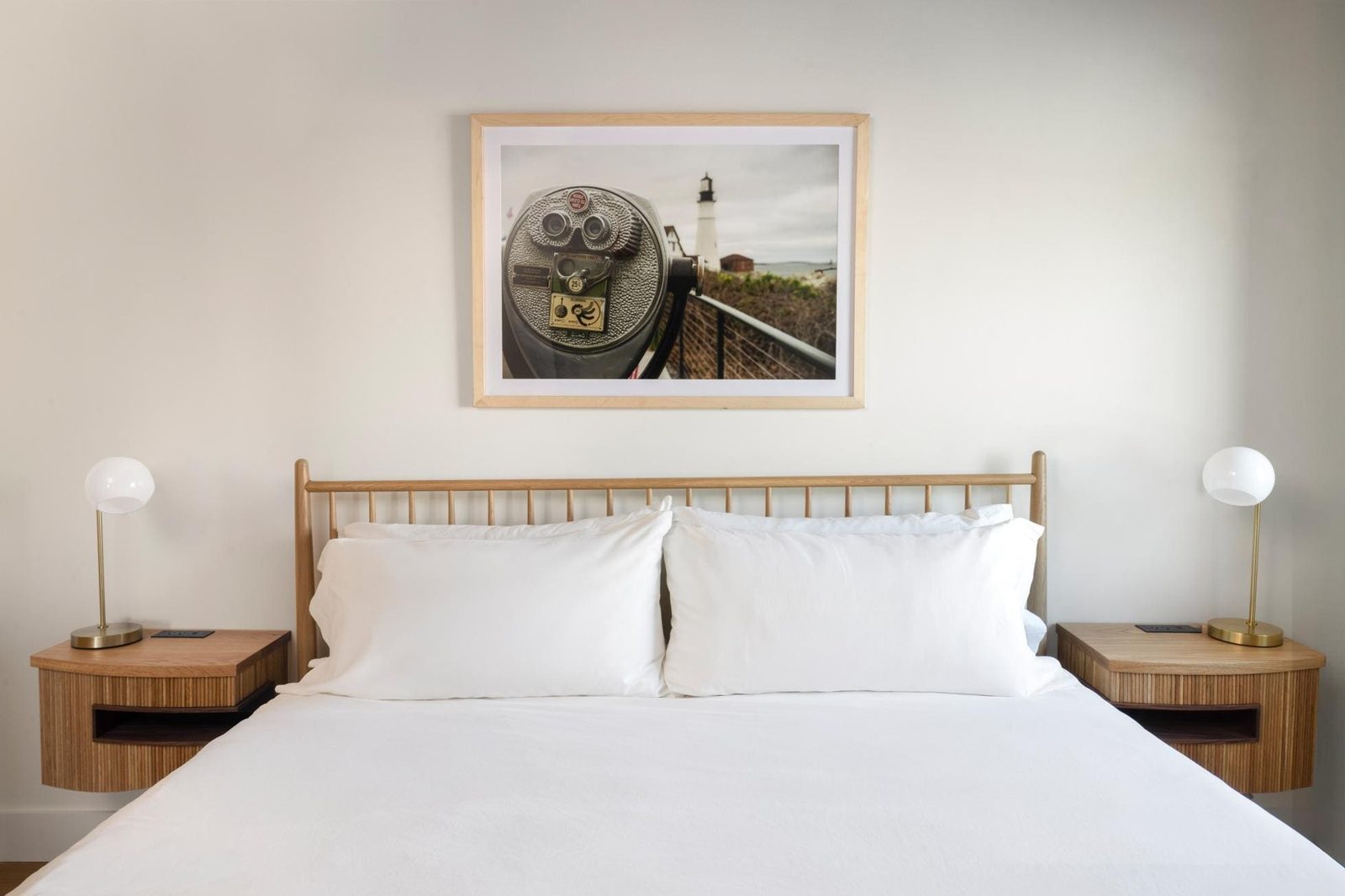 Bedroom with timber headboard and framed print at the Evalina Hotel