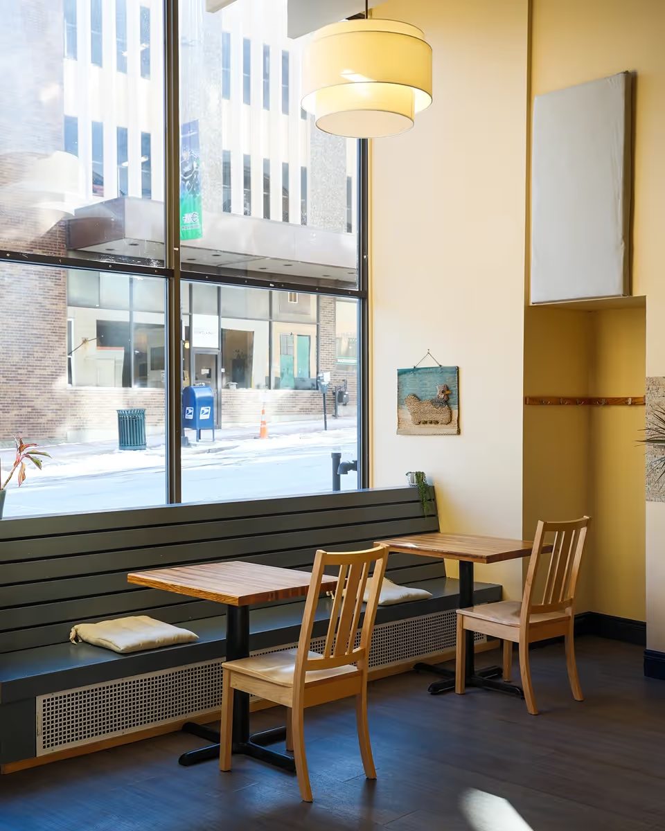 Corner banquette seating beside a large storefront window