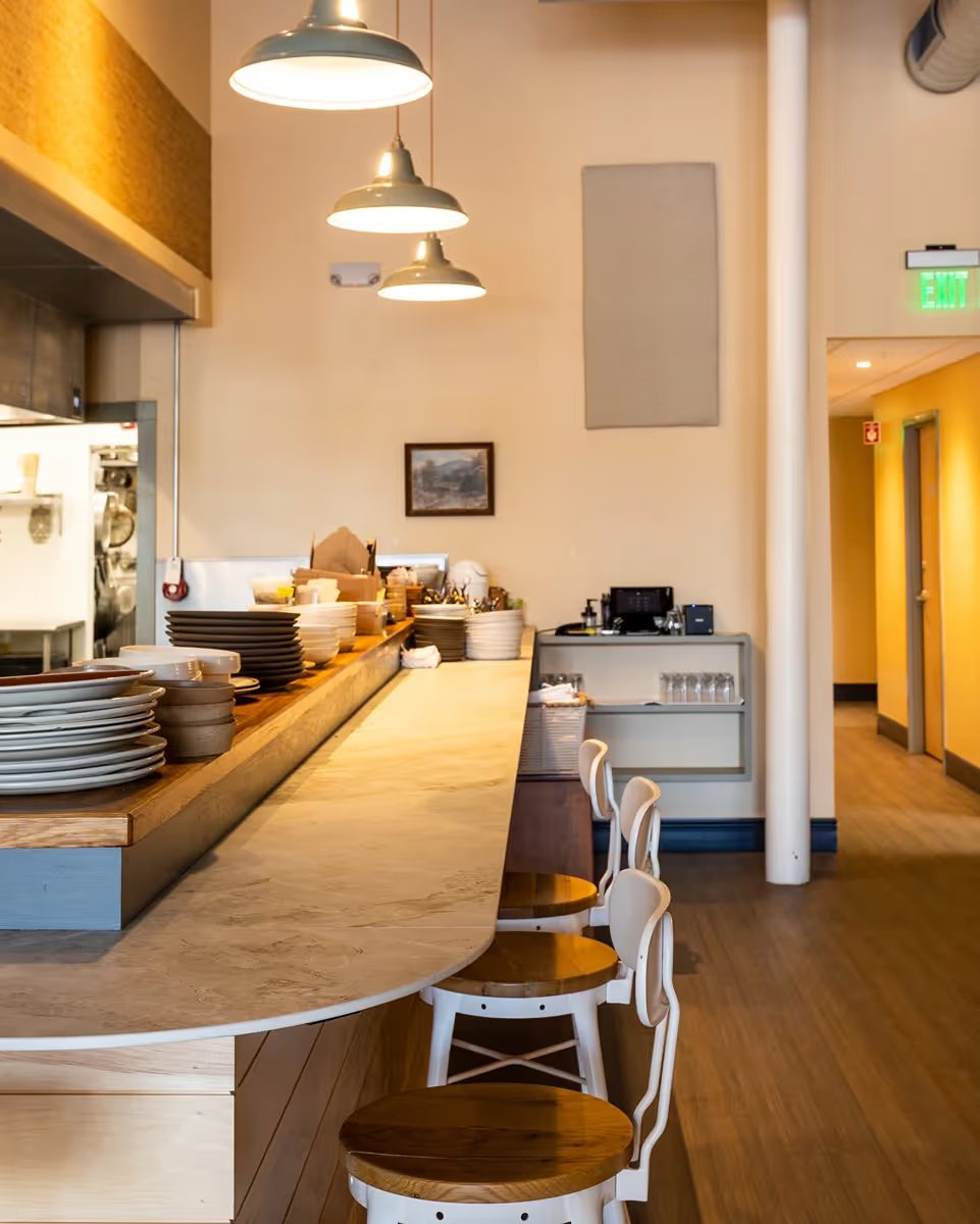 Open kitchen line with hood and pendant lighting