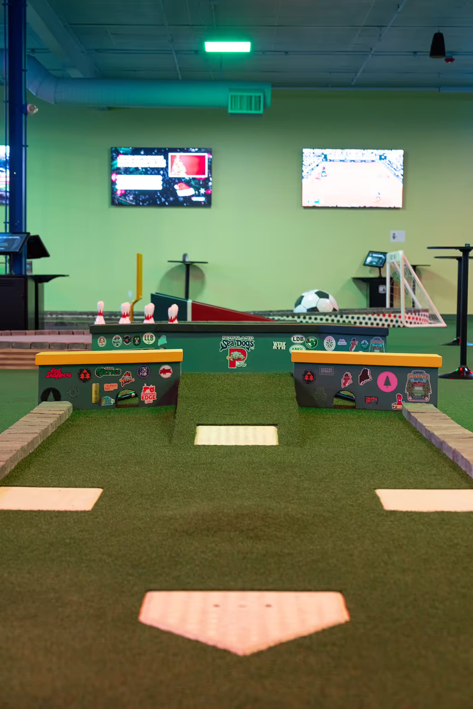 Exposed ceiling and ductwork above the minigolf course