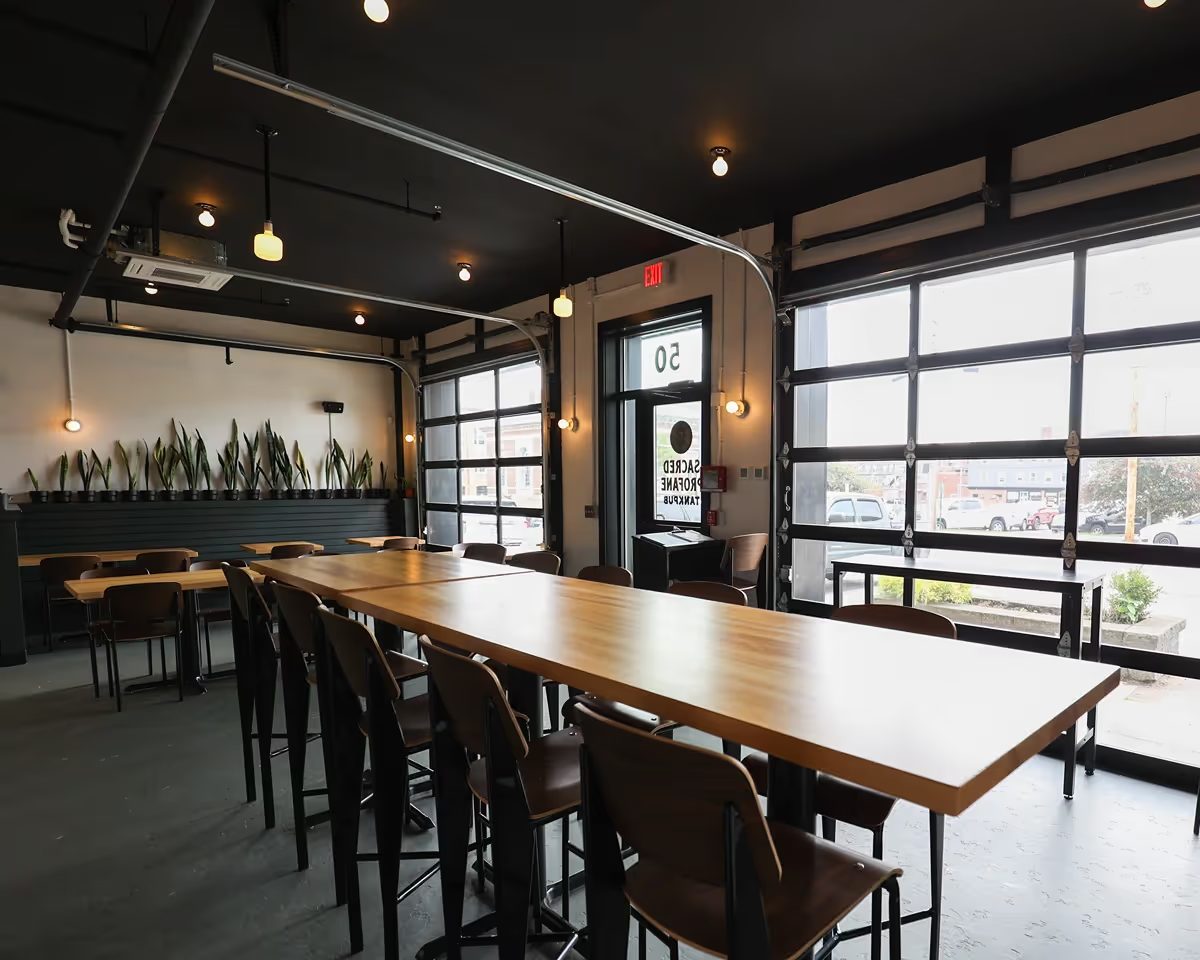 Taproom seating with overhead doors and communal tables