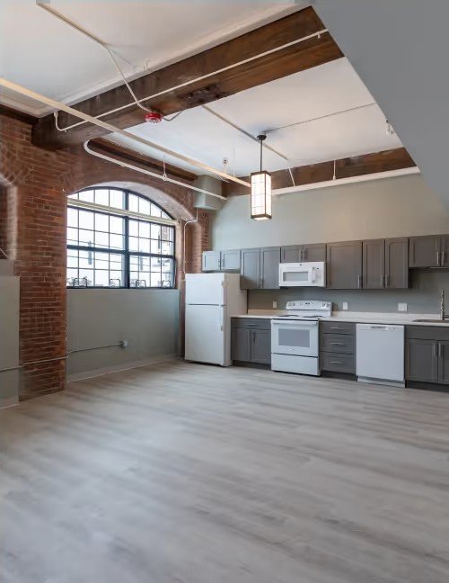 Open kitchen with arched mill windows and brick